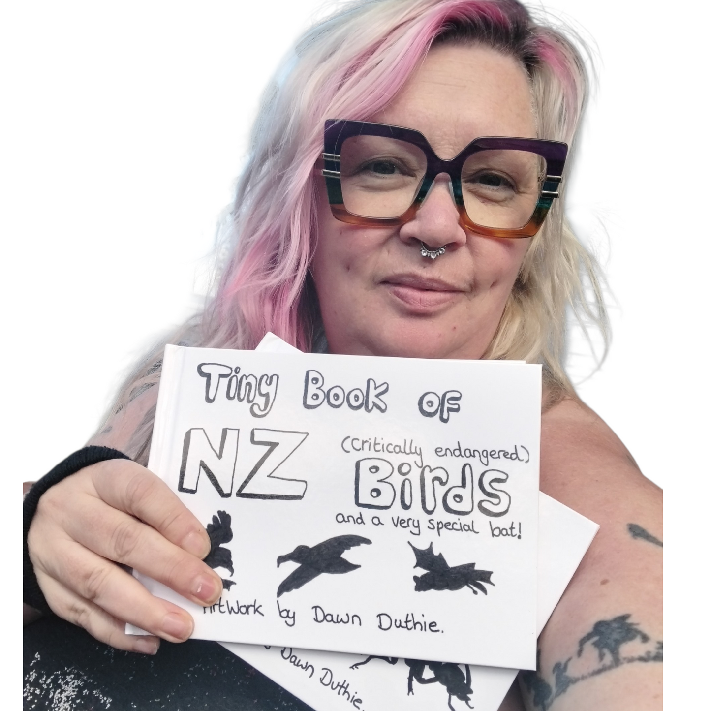 Dawn Duthie Upper Hutt Artist holding a 'Tiny Book of NZ Birds' Book with visible tattoos and glasses.