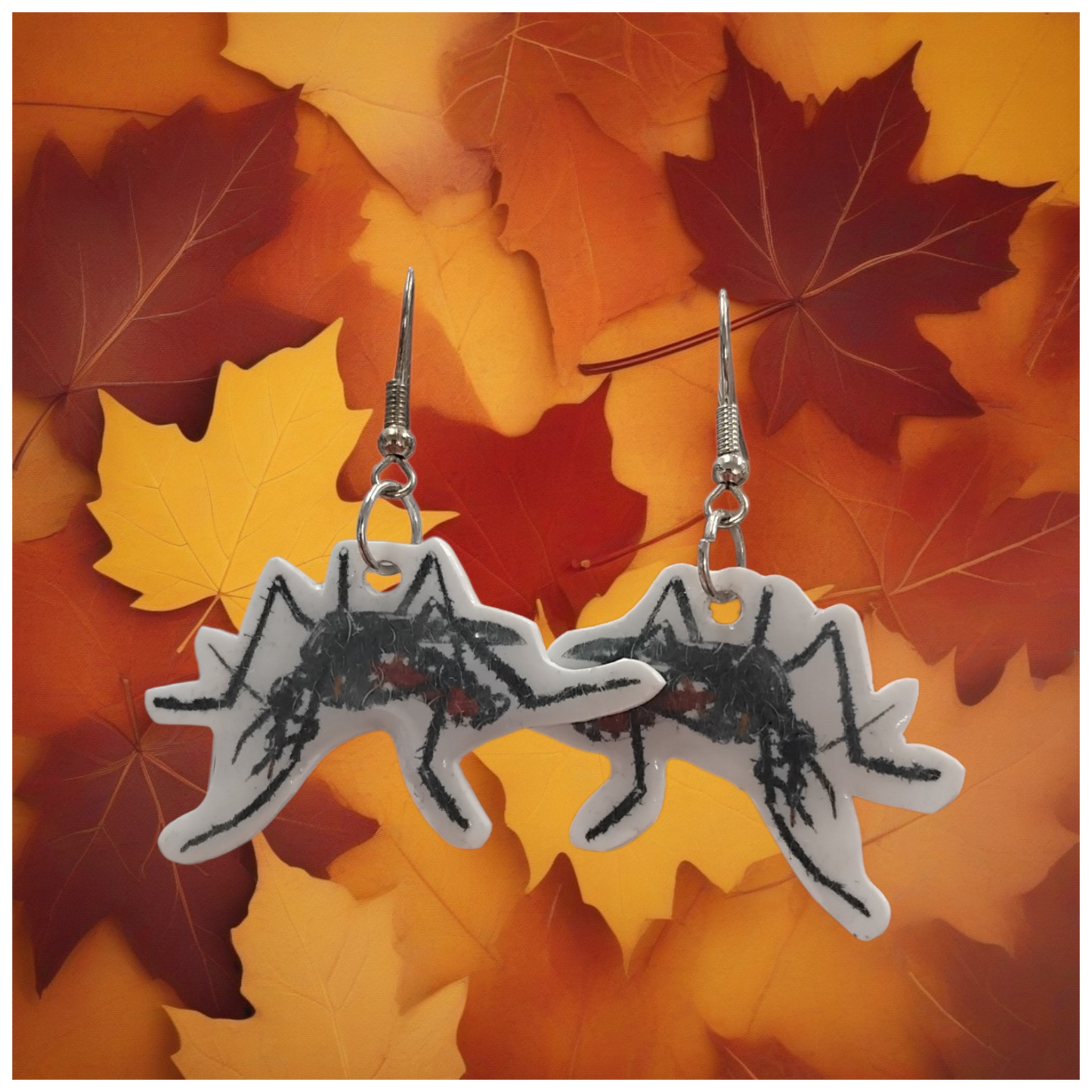 mosquito earrings on a background of autumn leaves
